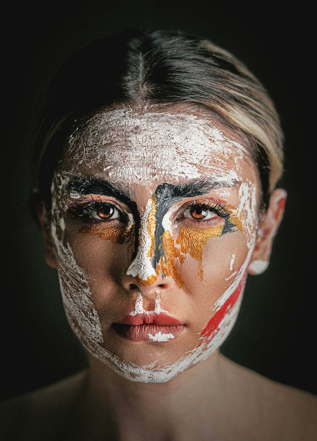 Woman's face is covered in abstract paint.