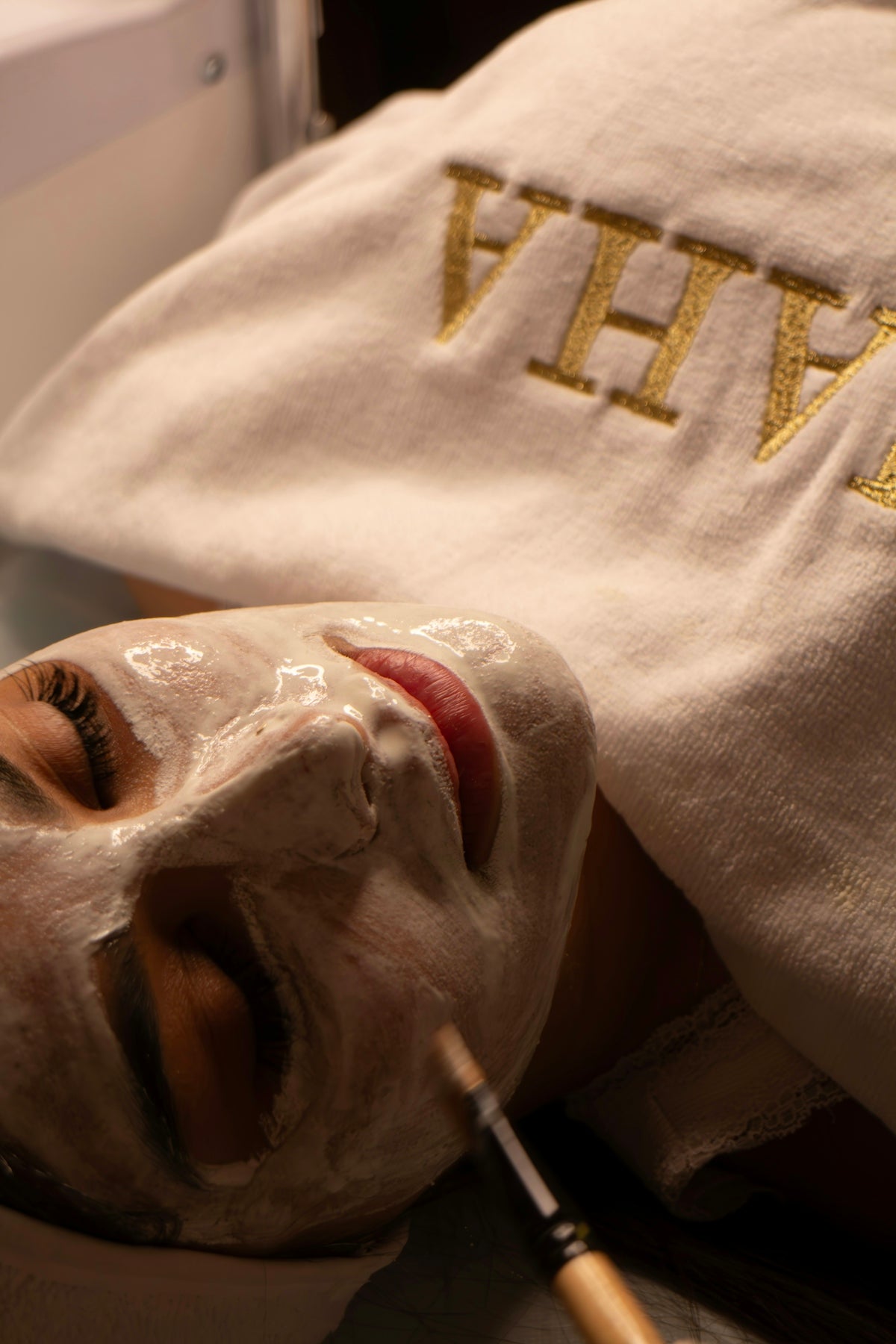 Woman receiving a facial treatment with a brush